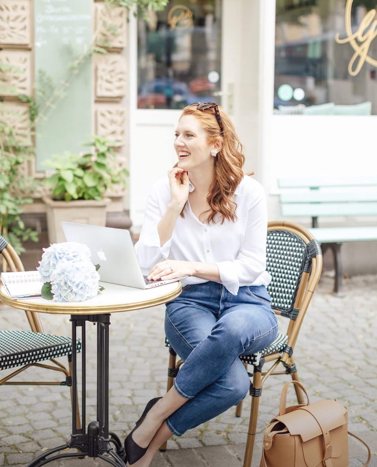 Paige Brunton sitting at an outside table at a cafe working