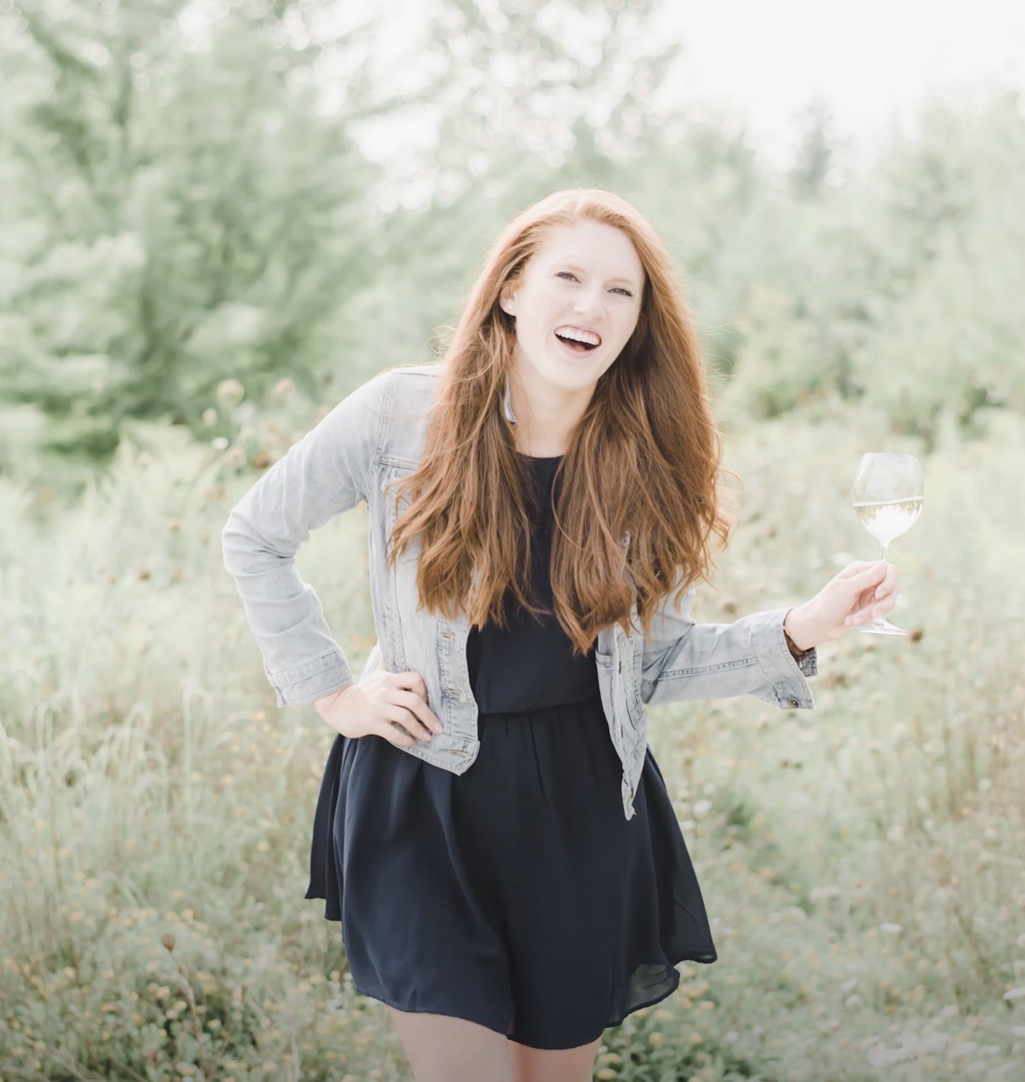 Paige Brunton holding a glass of champagne and looking toward the camera whilst laughing